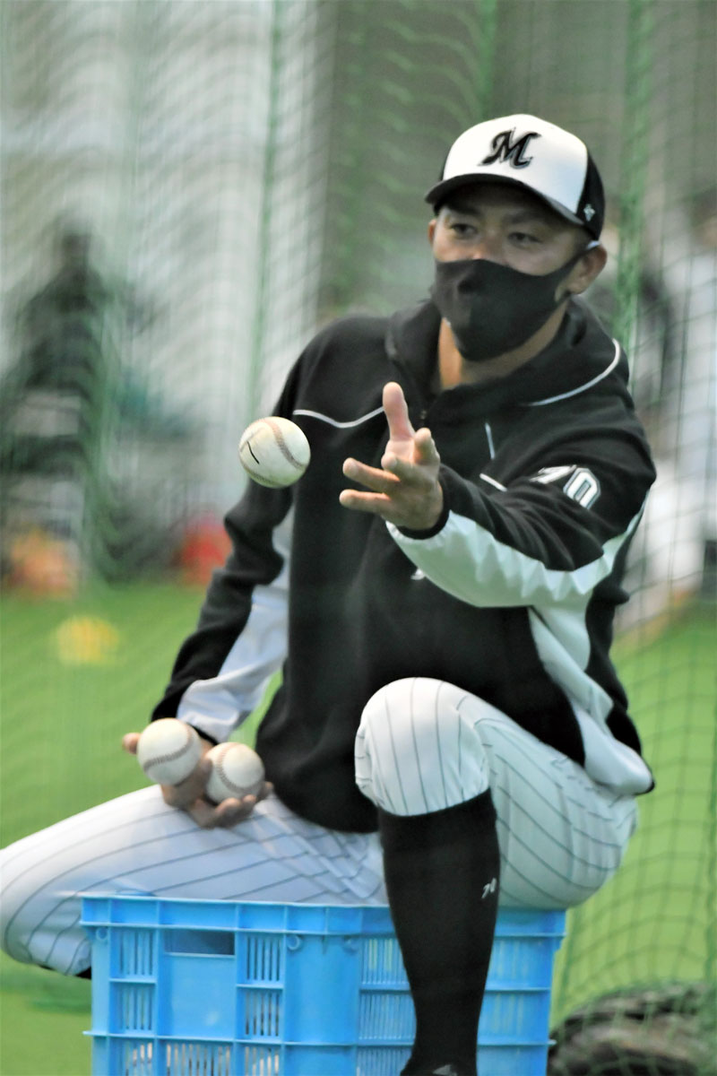 打撃練習でトスを上げる千葉ロッテの福浦1軍打撃コーチ=4日、沖縄県石垣市