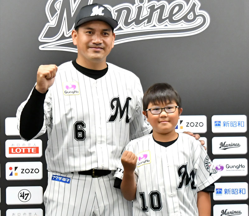 長期治療中の子どもを支援する「チームメイツ事業」で千葉ロッテに入団し、井口資仁監督（左）と記念写真に応じる宇都宮幹汰君＝１１日、千葉市美浜区のＺＯＺＯマリンスタジアム