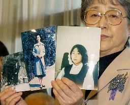 　北朝鮮側が提供した横田めぐみさんとみられる女性の写真を手にする早紀江さん＝２００４年１１月、東京・永田町の憲政記念館