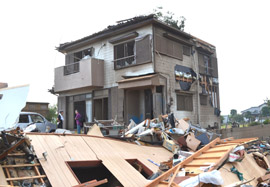 突風によりガラス窓や壁が壊れた住宅。手前の作業場も跡形もなく破壊された＝２日午後５時２５分ごろ、野田市岩名