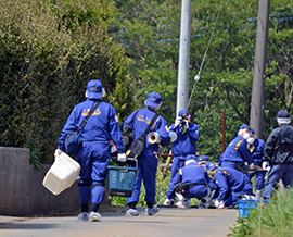 女性の遺体が見つかった現場付近を調べる捜査員=24日午後、芝山町大里