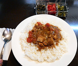 人気のポーク&トマトカレー（７００円）。付け合わせ（グリーンペッパー、福神漬け、ピクルス）は、宝石箱のような容器で提供される