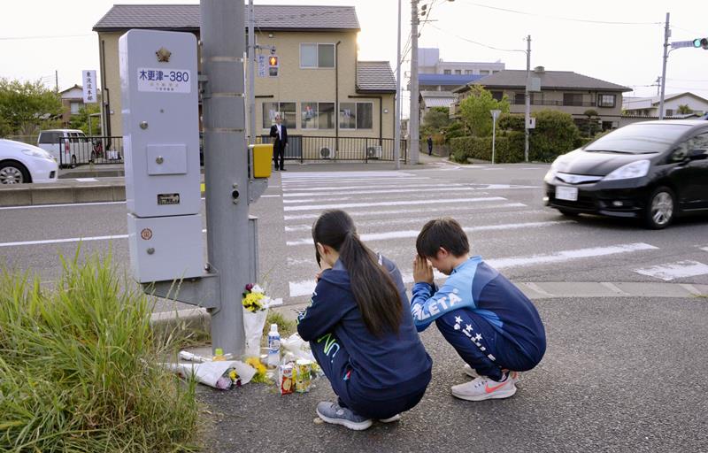 事故のあった現場付近に花を手向ける人たち＝２３日午後、木更津市江川（共同）