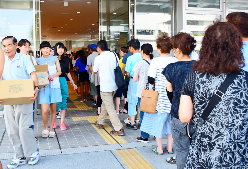 水と非常食の配給に並ぶ市民=10日午後、市原市役所