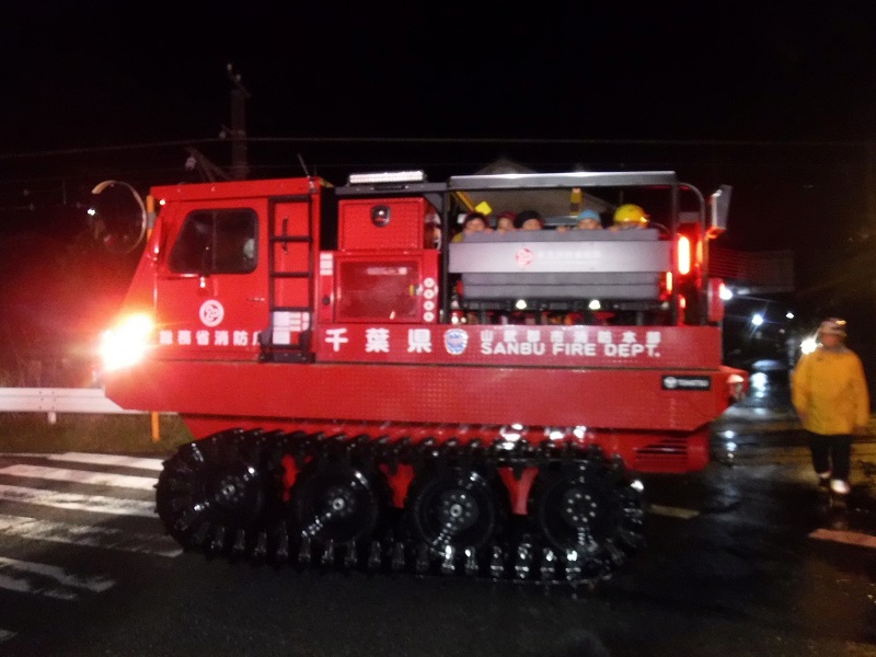 後ろの荷台に児童をのせ、幼稚園から冠水地帯を経て救助本部の拠点まで帰ってきた水陸両用車=25日午後8時20分ごろ、山武市(山武郡市広域行政組合消防本部提供)