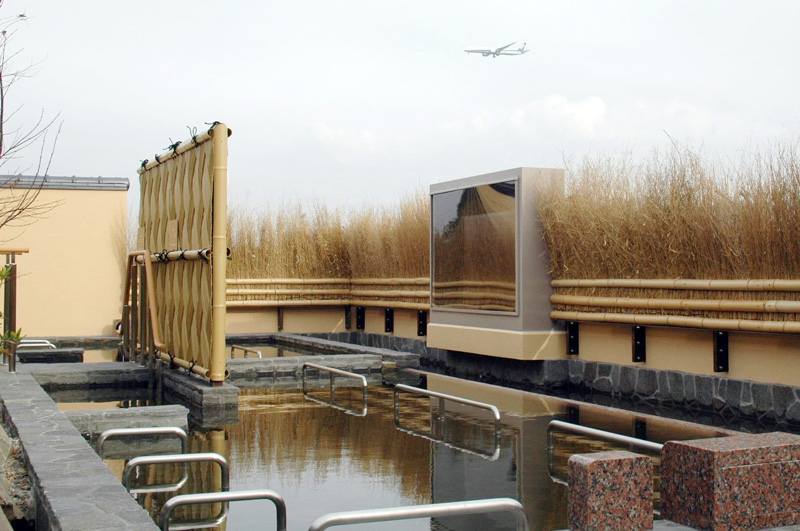 露天風呂にゆったりと漬かりながら、成田空港を離着陸する航空機が眺められる。大画面ではフライトレーダーが映し出される=11日、成田空港温泉空の湯