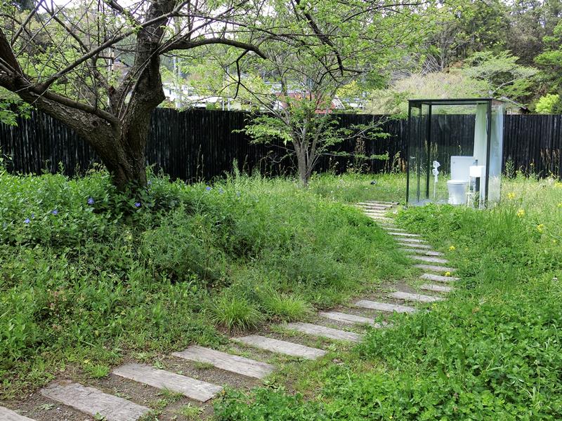 作品「Toilet in Nature」。広い敷地内にガラスで覆われたトイレがぽつんとある様子は不思議な味わい