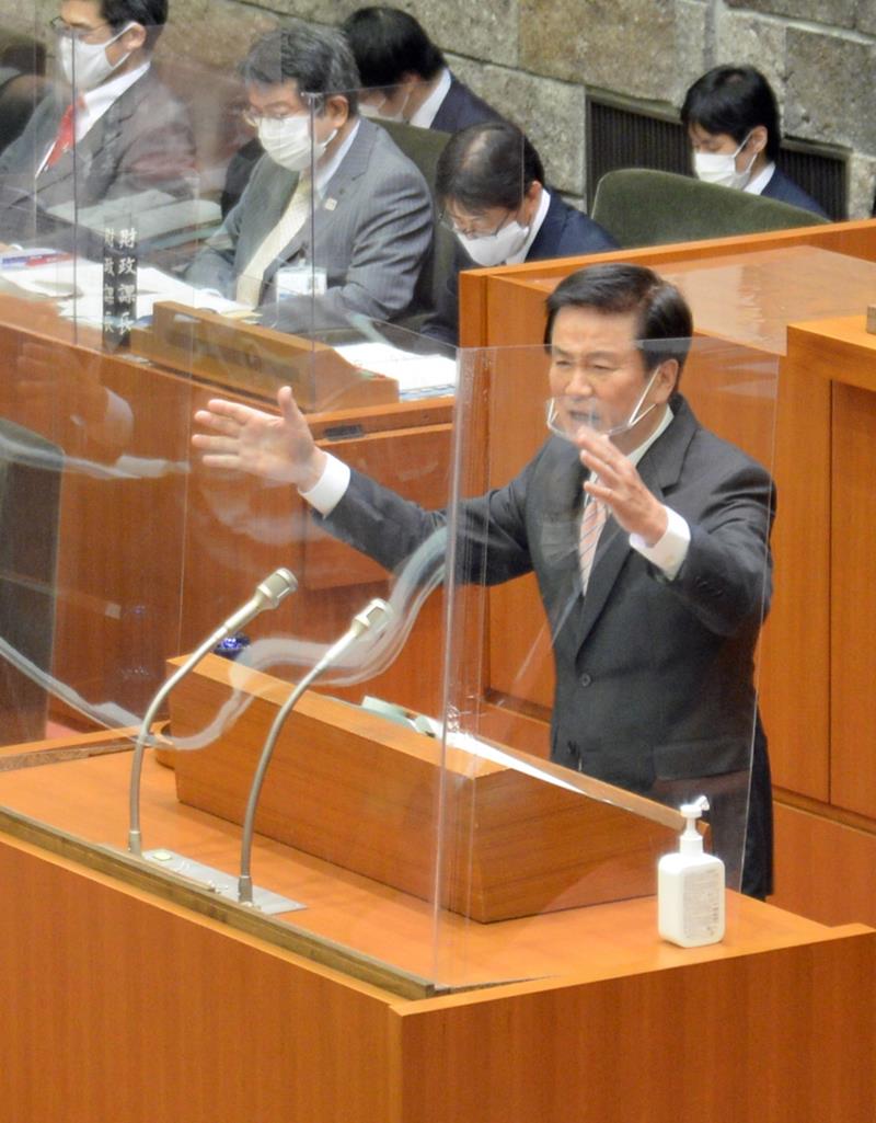 手振りを交え、アクアライン800円化の運動を共にしてきた高橋浩県議への質問に答える森田千葉県知事=9日、県議会本会議場
