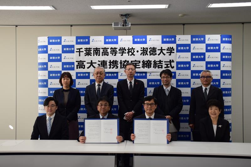 協定書を持つ磯岡学長（前列右から２人目）と富田校長（同３人目）＝淑徳大