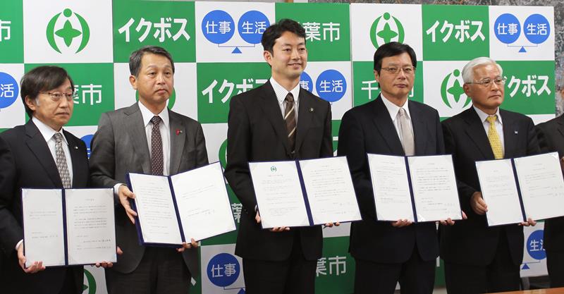 2015年11月、産官学共同で「イクボス」増加を目指す宣言書を手にする千葉市の熊谷俊人市長(中央)ら=千葉市役所