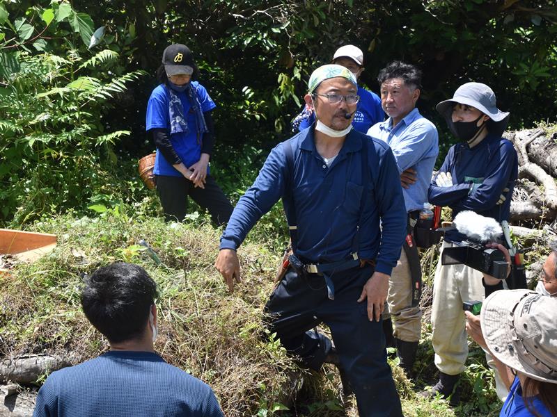 沖ノ島の現状やタブノキの植え方を説明する高田さん