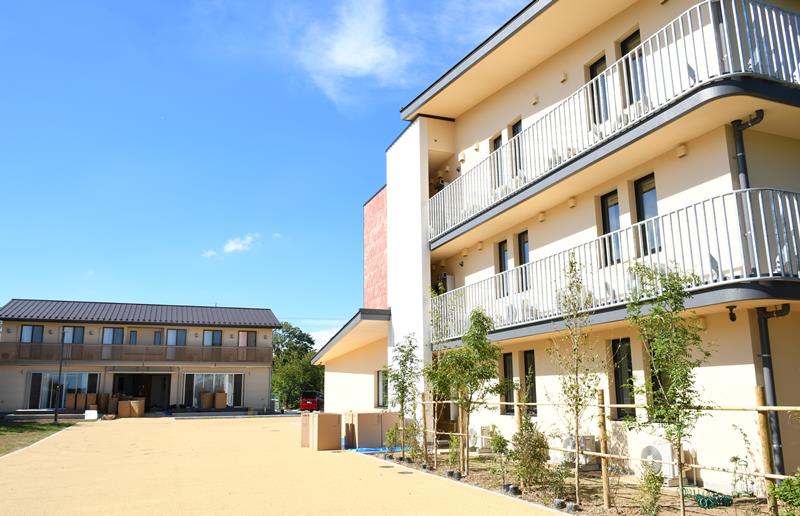 新築された成田学園の小学生らの園舎（右）と中高生の園舎