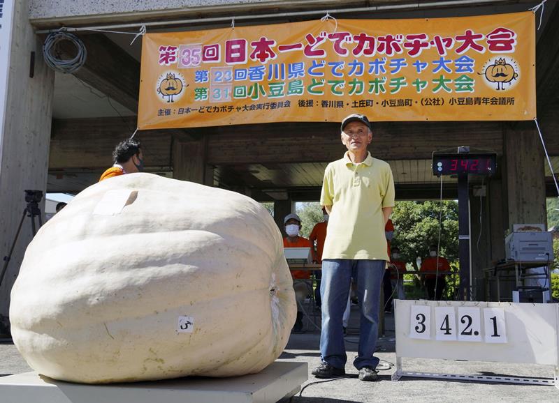 カボチャの重さを競う「日本一どでカボチャ大会」で３位の内田英徳さん＝１９日午前、香川県の小豆島（共同）