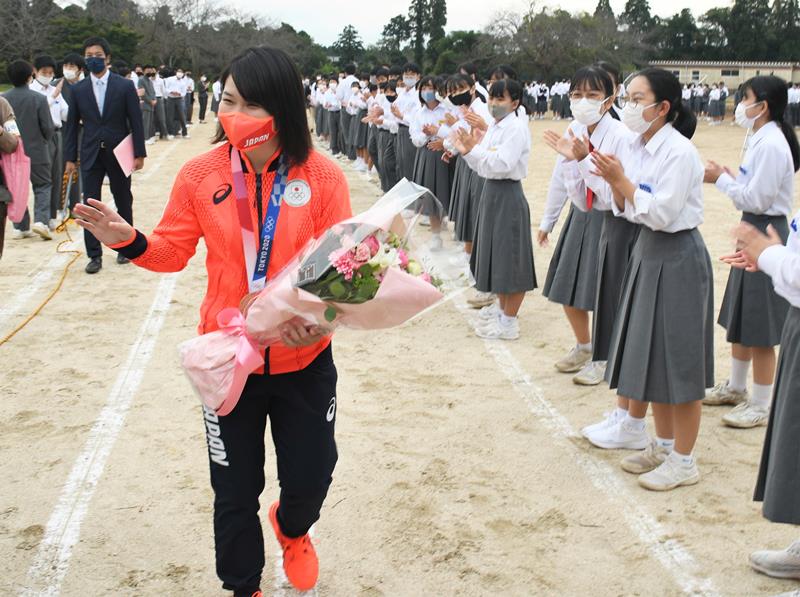 母校の生徒たちが作った花道を歩く並木選手＝成田市