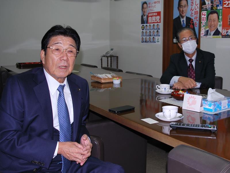 テレビの選挙速報を見つめる自民党県連の河上茂幹事長（左）と本間進県議会議員会長＝３１日、千葉市中央区