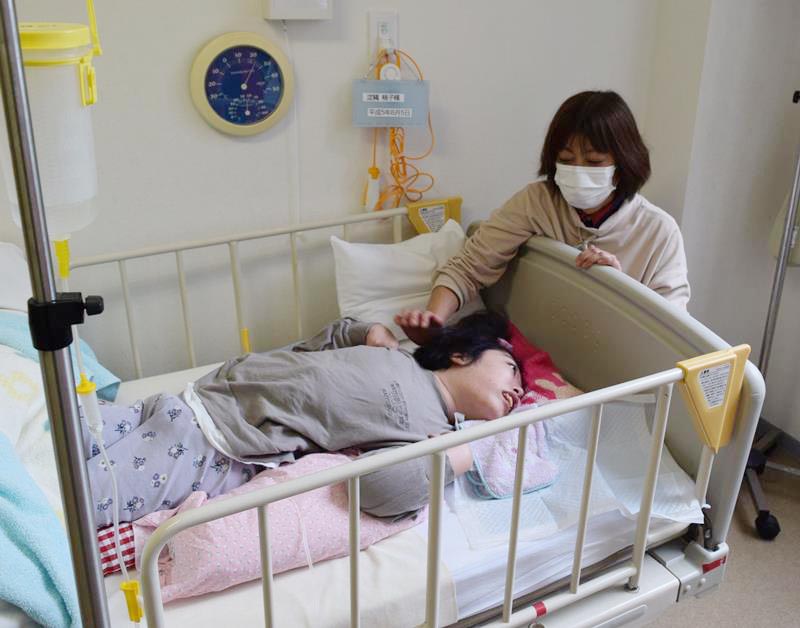 晴山苑の医療型短期入所を利用する淀縄さん。右は母親の喜代美さん=千葉市花見川区