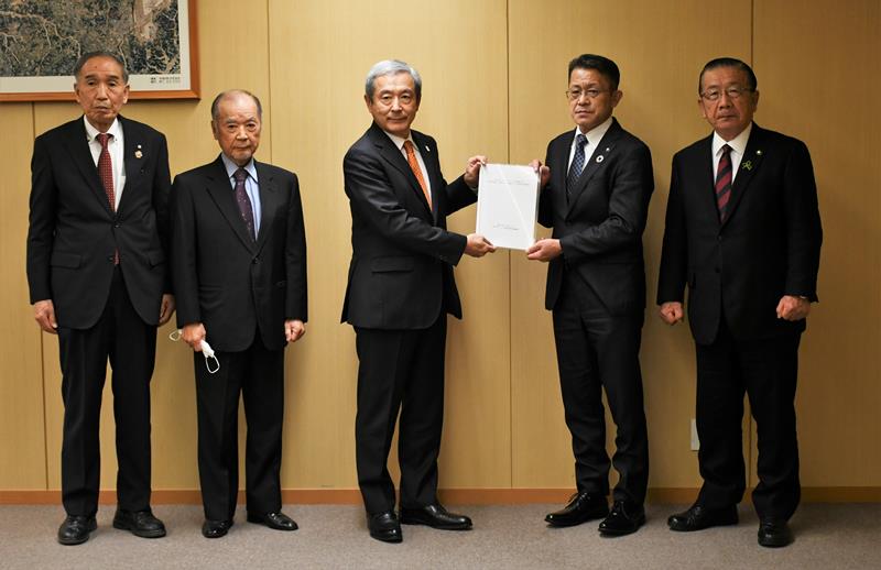 田村社長（左から３人目）に要望書を手渡す五十嵐市長ら＝成田市のＮＡＡ本社
