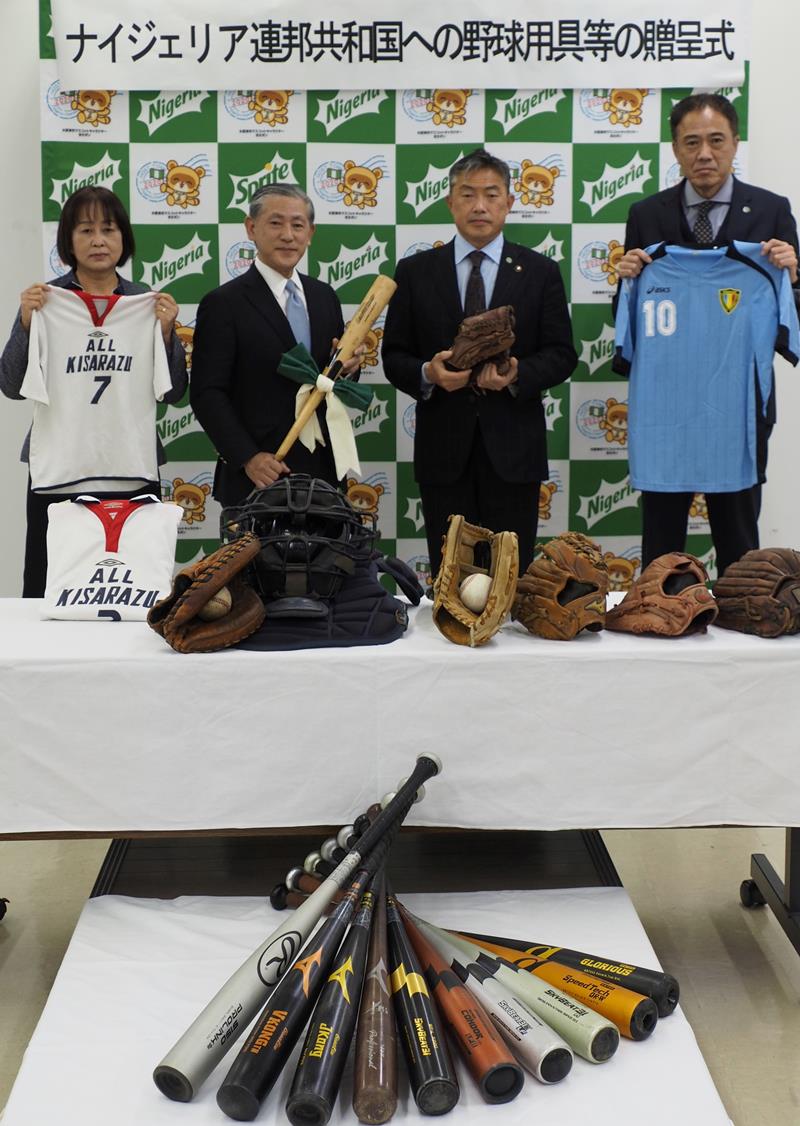 ナイジェリアの青少年に寄贈する野球用具を手にする松永大使（左から２人目）と渡辺市長ら＝木更津市役所
