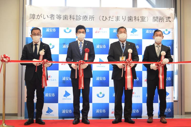 ひだまり歯科室の開所式でテープカットで祝う牧口さん（左）ら＝浦安市