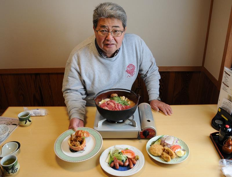 イノシシ肉を使ったジビエ料理を紹介する中村さん。鍋とウインナー以外は要予約＝市原市の「八幡屋」