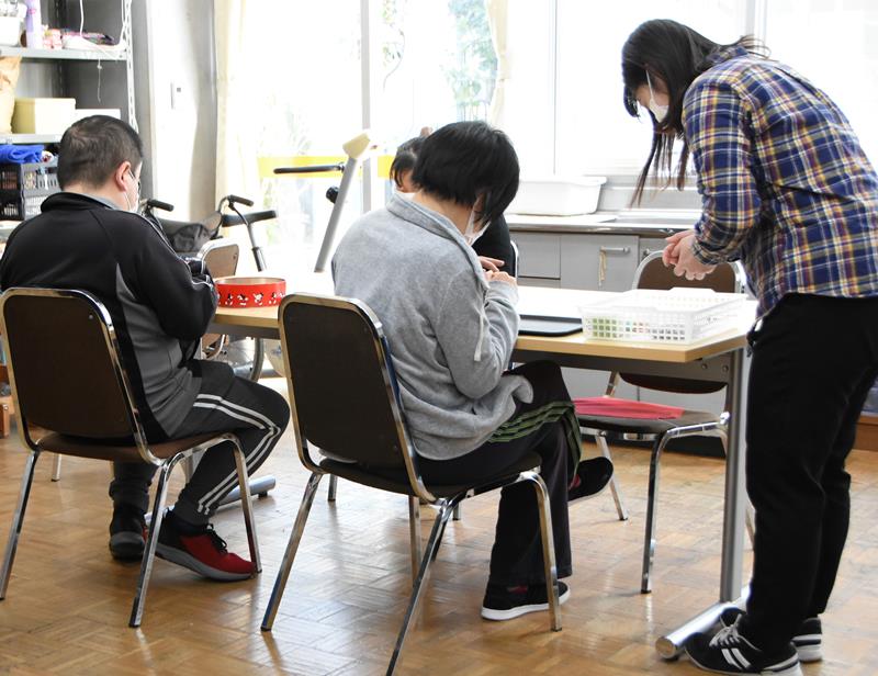 職員と一緒に手芸に取り組む「でい・さくさべ」の通所者ら＝千葉市稲毛区