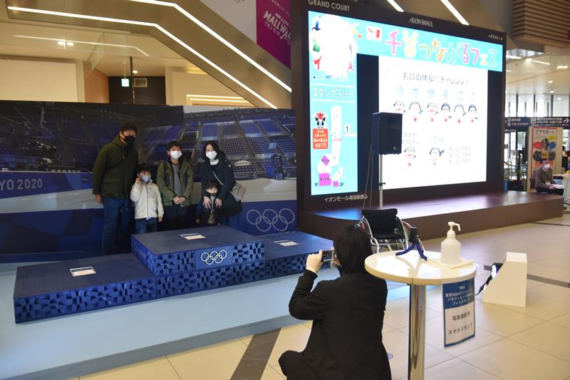 国枝選手が上がった表彰台と一緒に記念撮影する来場者＝千葉市美浜区のイオンモール幕張新都心