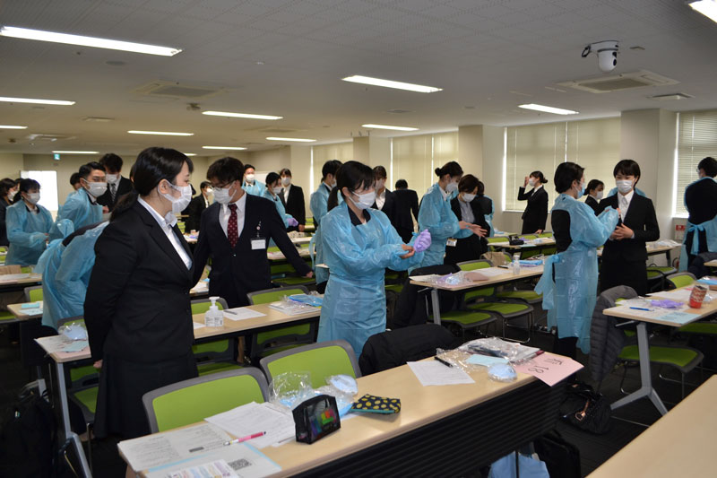 新型コロナ感染対策として、新入職員は医療用ガウン着脱の練習を行った＝１日、千葉市中央区の千葉大病院