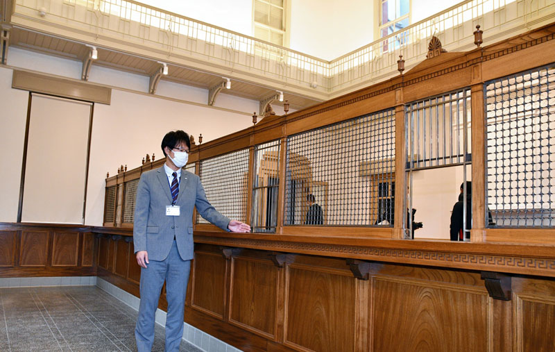 工事が完了した佐原三菱館の受付カウンターなどの内装について説明する担当者