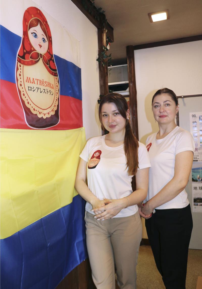 千葉市中央区でロシア料理店「マトリョーシカ」を経営するステッツク・アナスタシアさん（右）と娘のダイアナさん。店内にはロシアとウクライナの国旗が飾られている＝１１日