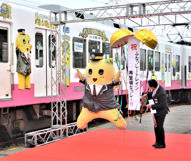 ふなっしーの“地上降臨”１０周年を記念した新京成の特別塗装電車の披露式で、飛び跳ねて喜ぶふなっしー＝２０日、鎌ケ谷市のくぬぎ山車両基地