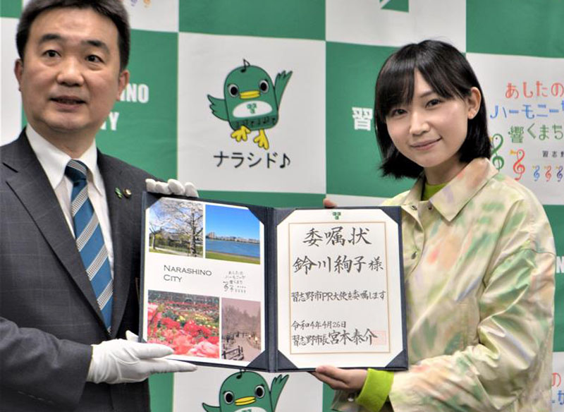 習志野市初のPR大使に就任し、委嘱状を宮本市長(左)から受け取る同市出身タレントの鈴川絢子さん=26日、習志野市役所