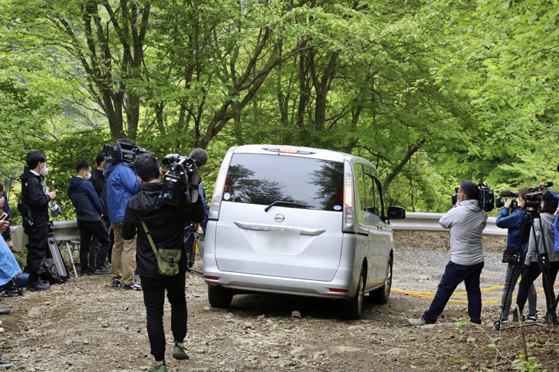規制線が張られた現場周辺に入る山梨県警の捜査車両＝２８日午前、山梨県道志村（共同、画像一部加工）