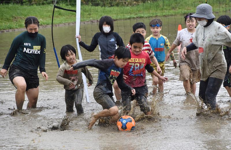 泥だらけになりながらボールを追いかける子どもたち＝２９日、鴨川市