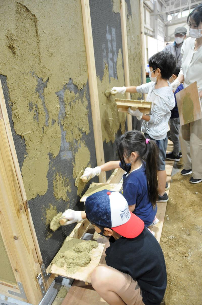 土壁塗りに挑戦する子どもたち＝市原市の歴史体験館
