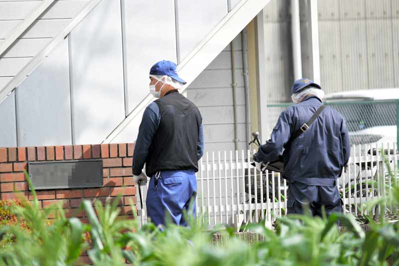 2人の遺体が見つかったアパート付近で鑑識作業を進める捜査員=26日午前8時40分ごろ、富里市七栄(写真は一部加工してあります)