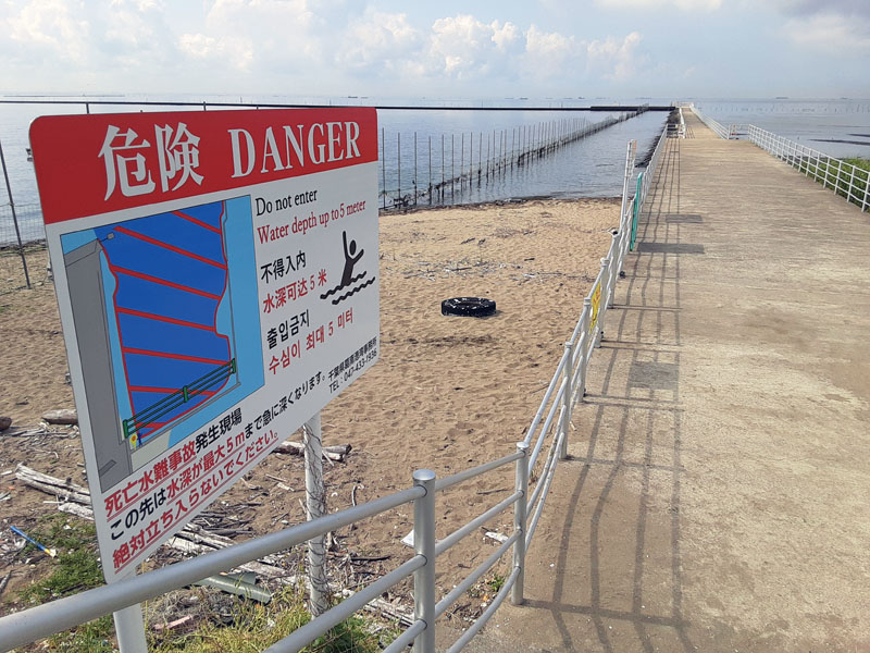 砂浜に立てられた「危険」の立て看板＝２日午前８時半ごろ、船橋市潮見町周辺