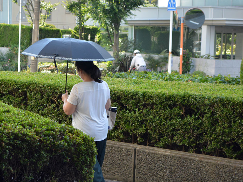 建物を出てすぐに日傘を差す女性＝３０日午後３時半すぎ、船橋市内