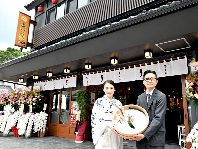外国人観光客の来店を意識し、和洋折衷の新店を開業した菊屋の石橋幸太郎社長（右）と妻でおかみの真衣子さん＝成田市の成田山参道