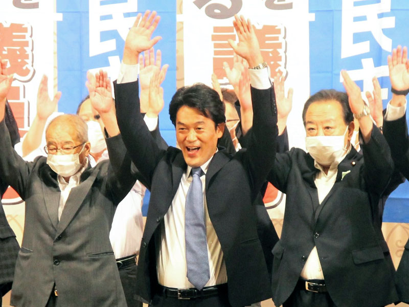 ３選を決め、万歳三唱する小西氏（中央）＝１０日、千葉市中央区