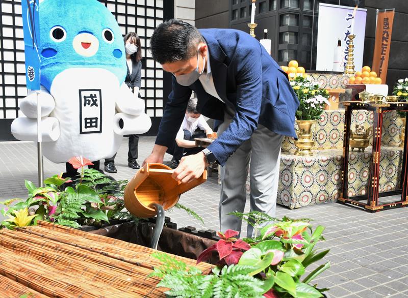 感謝を込めて放生池にウナギを放す参列者=15日、成田市