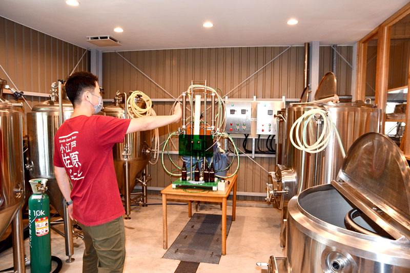 クラフトビールの醸造設備を説明する小林さん＝香取市