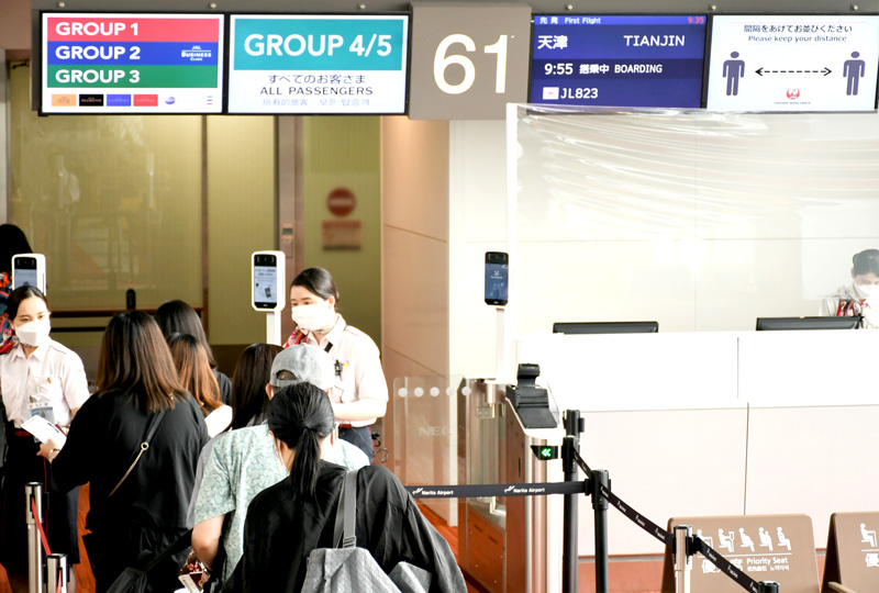 日本航空の成田発中国・天津線の搭乗ゲートに並ぶ旅客ら=16日、成田空港