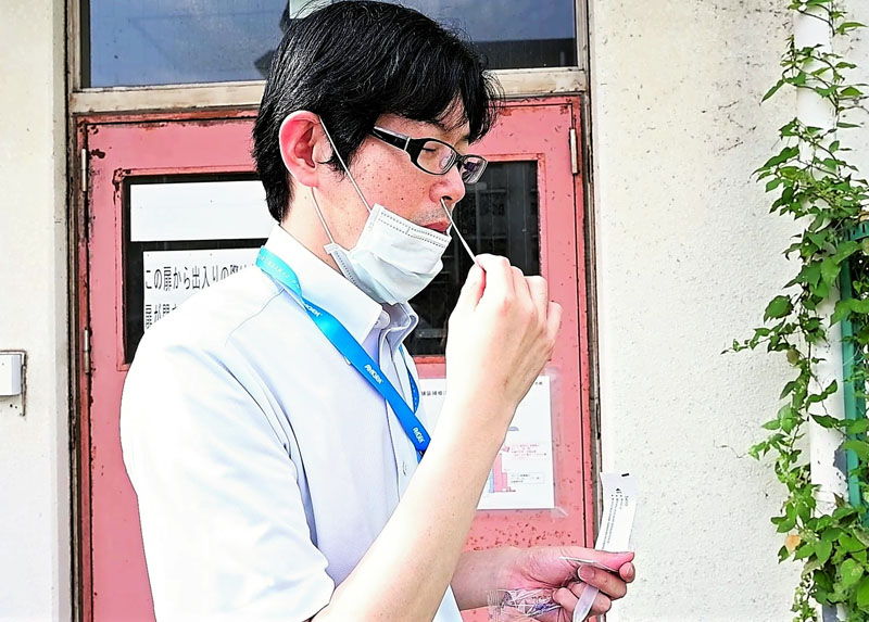 出勤時に抗原検査を行う医師(千葉大病院提供)