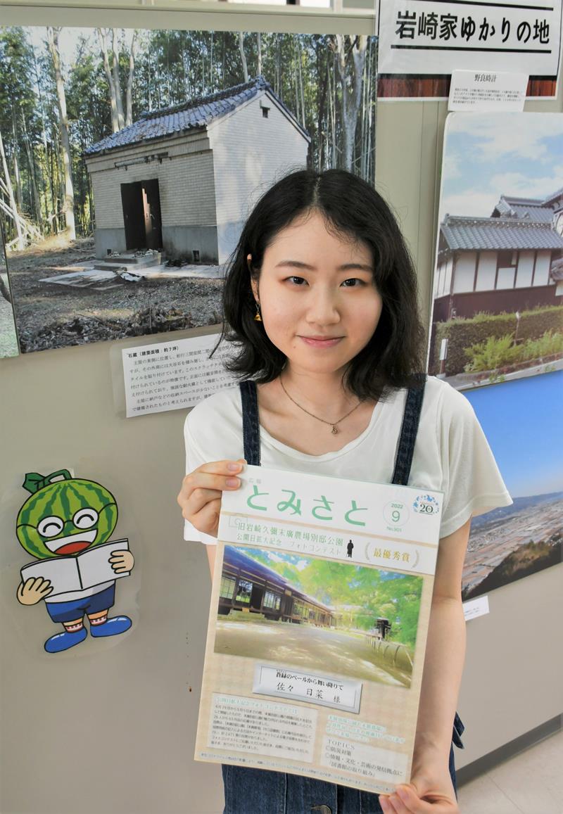 自身が撮影した岩崎別邸の写真が表紙に載った富里市広報紙を紹介する佐々さん＝同市役所