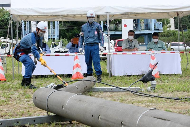 訓練で倒れた電柱の通電状況を確認する東京電力の作業員＝９日、千葉市中央区