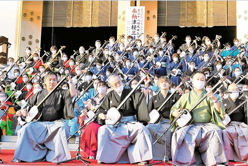 成田山新勝寺の大本堂を前に演奏する約１３０人の三味線奏者＝成田市