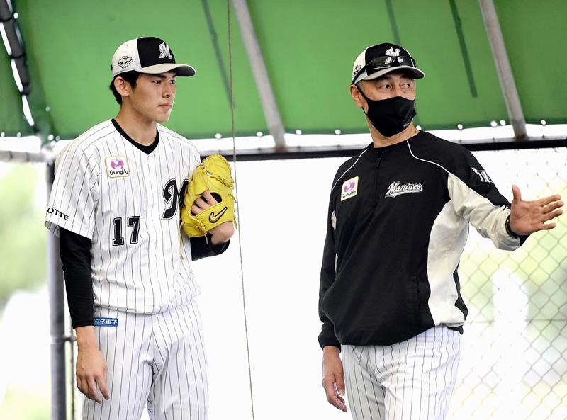 昨年の春季キャンプで千葉ロッテ・佐々木朗（左）と話をする吉井氏＝昨年２月、石垣（代表撮影）