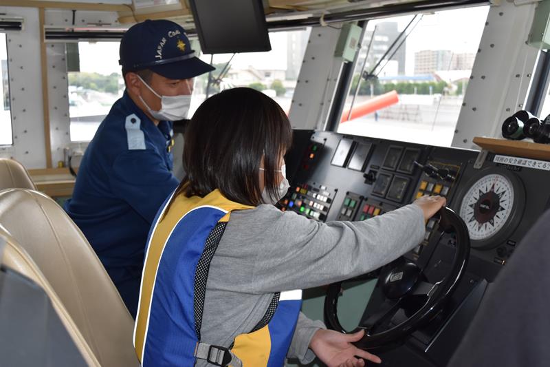 巡視艇「たかたき」の操縦を体験する子ども＝２２日午後、千葉市中央区の千葉港