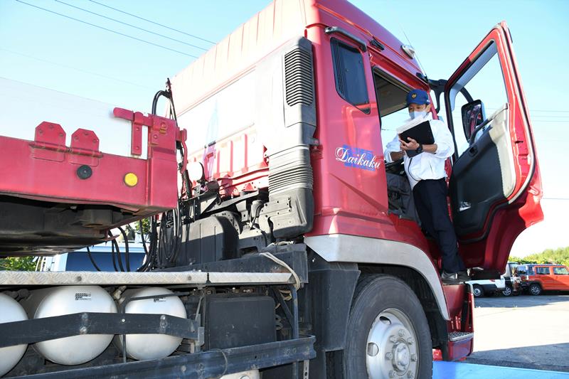 大型車の運転手に脱落防止に向けた注意を促す千葉運輸支局の職員＝１０月２６日、成田市
