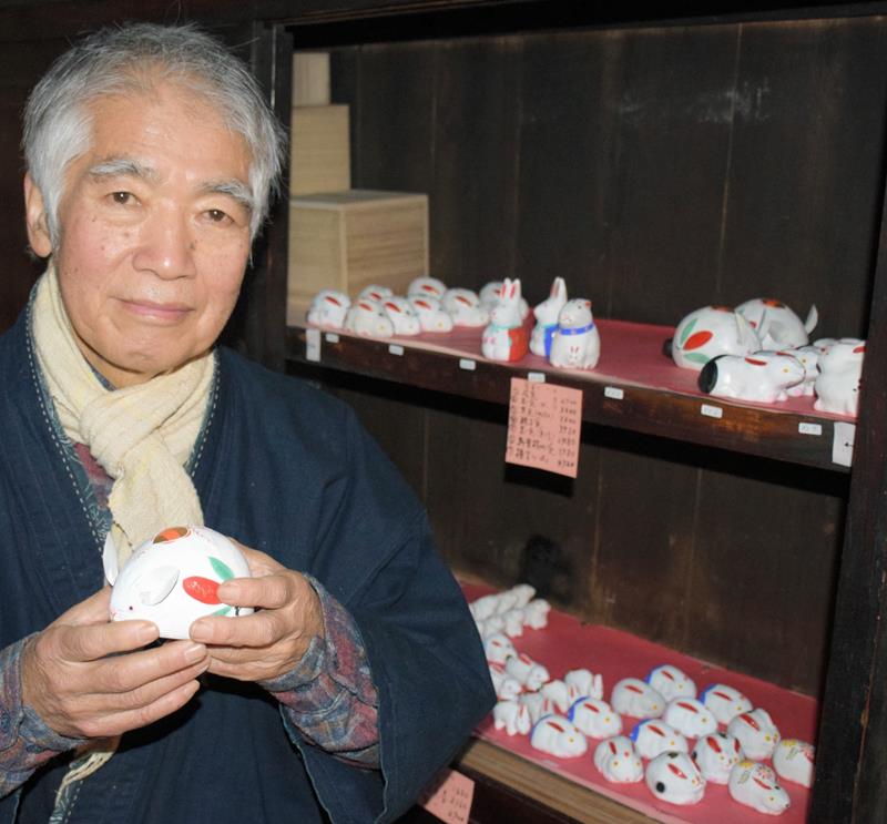 制作した兎を手にする千葉惣次さん。ぬくもりある作品が並ぶ＝１９日、長南町